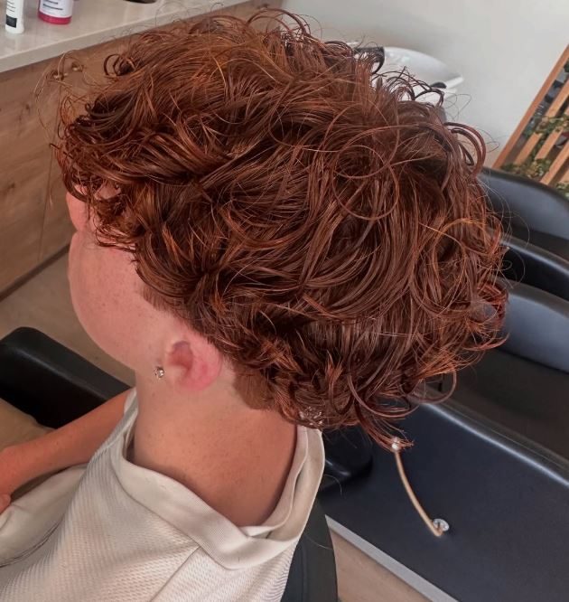 Coppery auburn perm with soft, springy curls on a male client at Hair Palette Beauty Salon